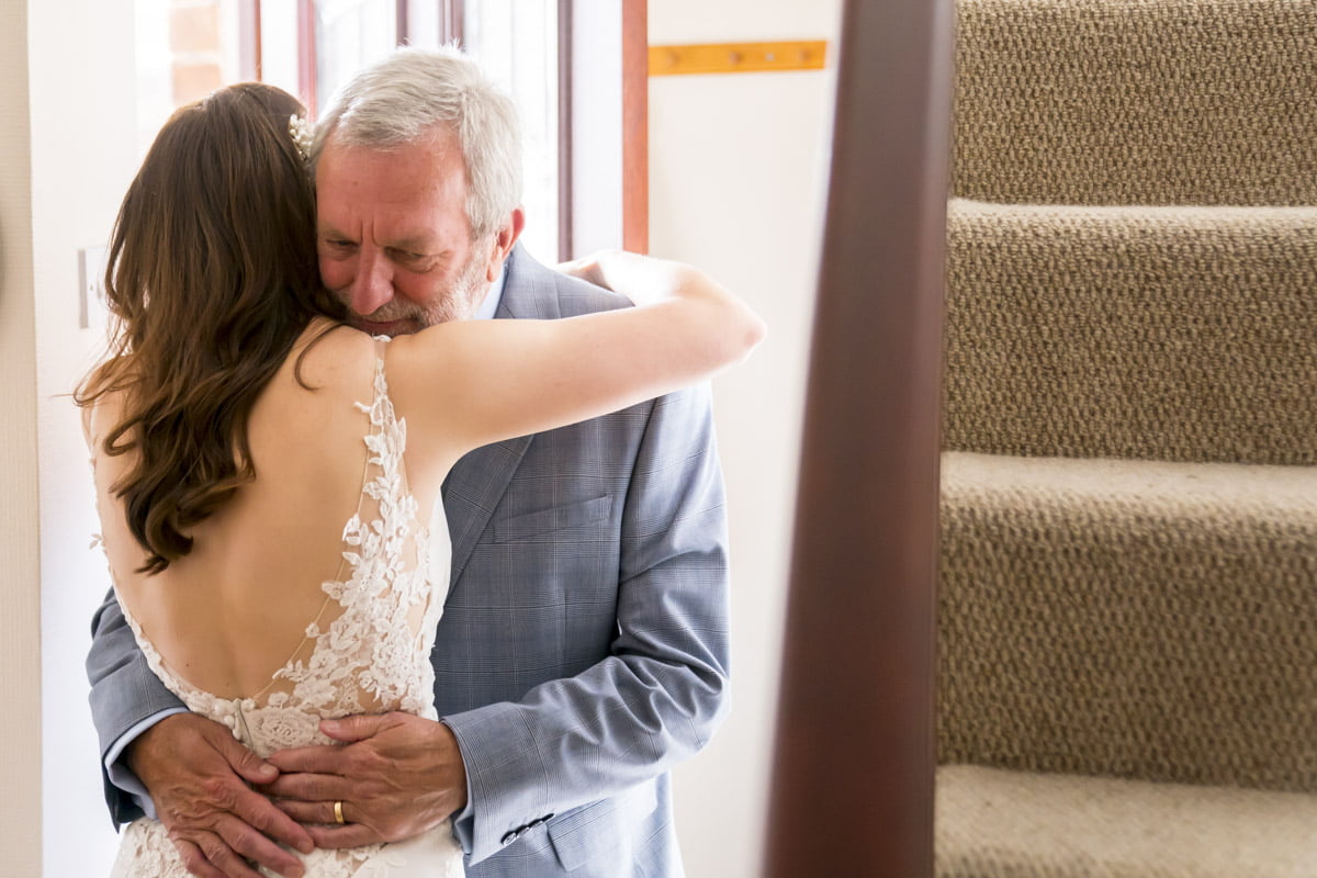 The bride hugs her father after he sees her for the first time