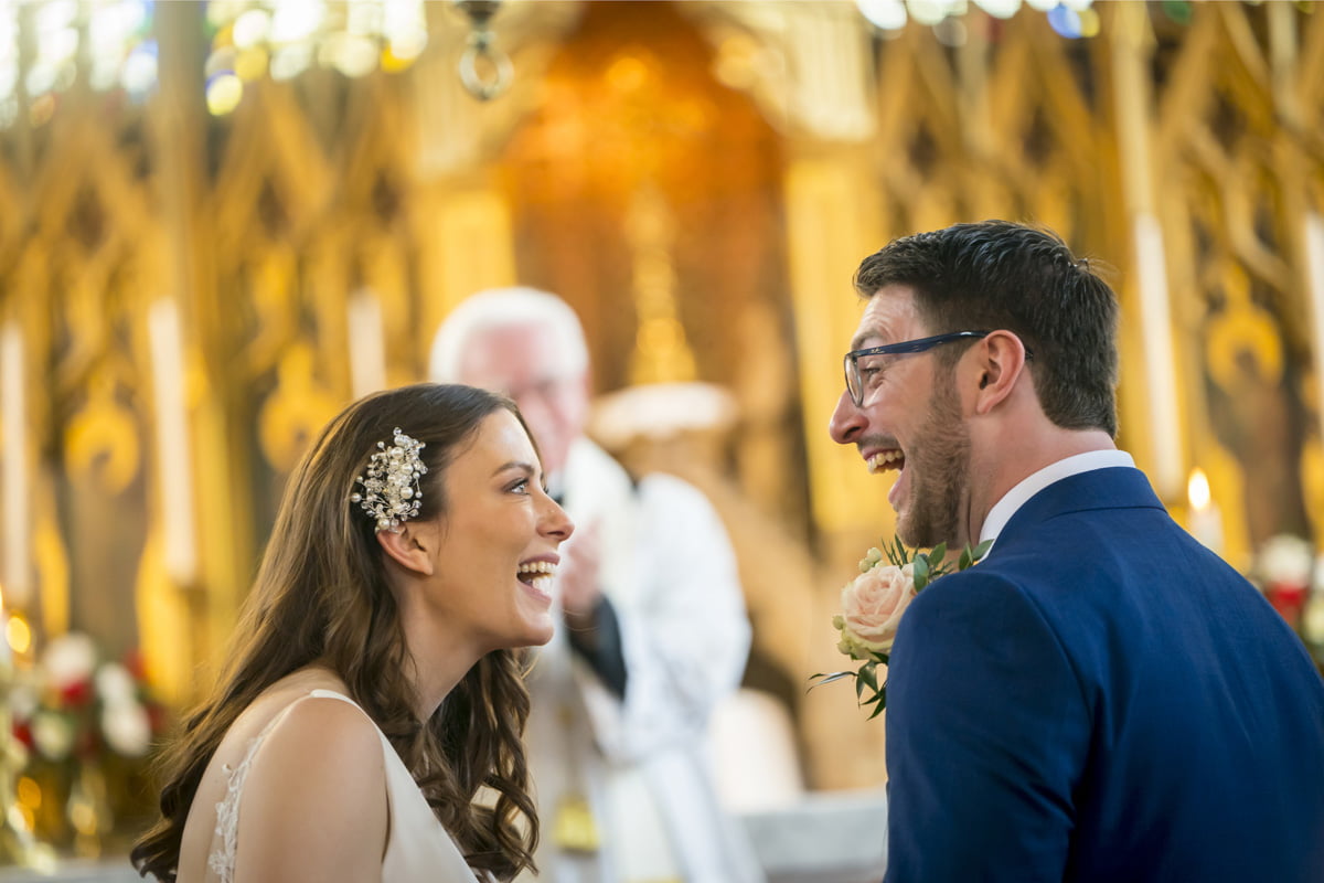 The bride and groom laugh together at St Mary’s RC Church