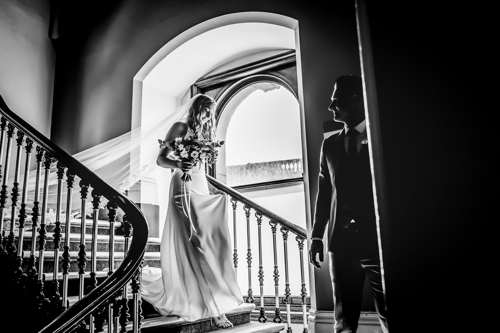 The bride walks down the stairs before the ceremony