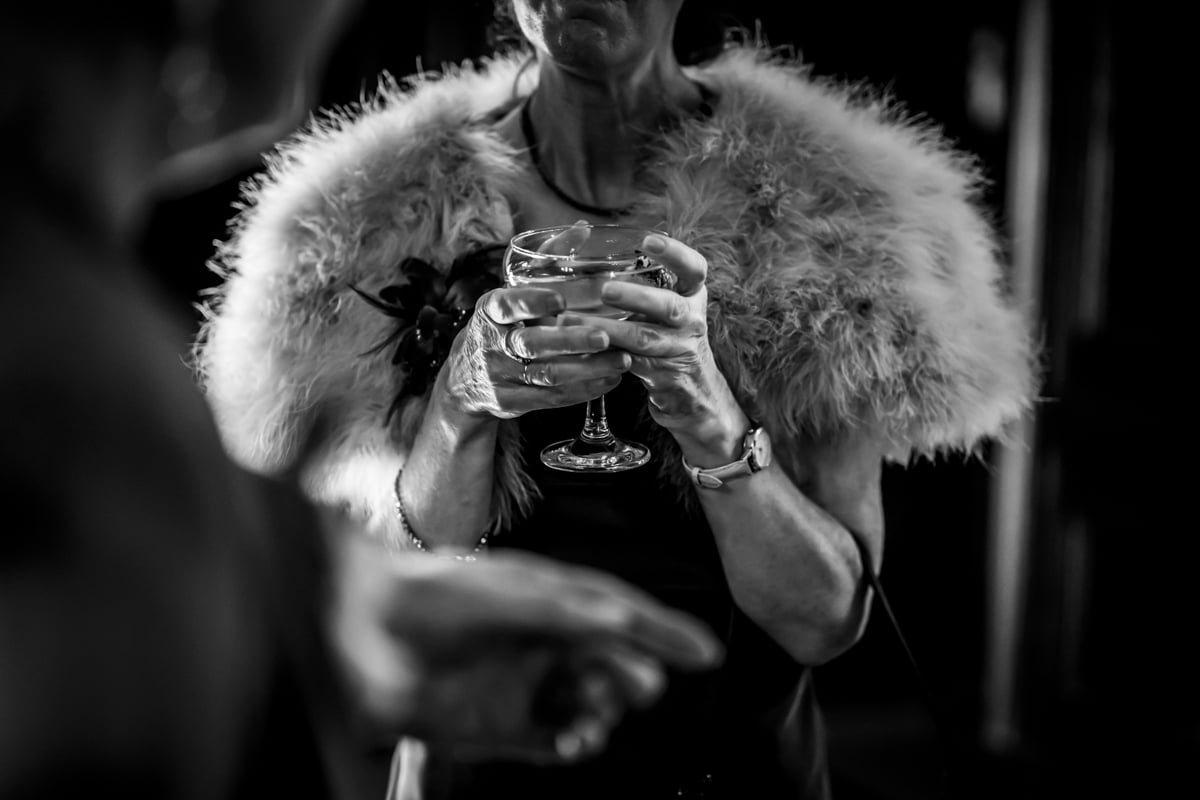 A guest clutches a champagne saucer