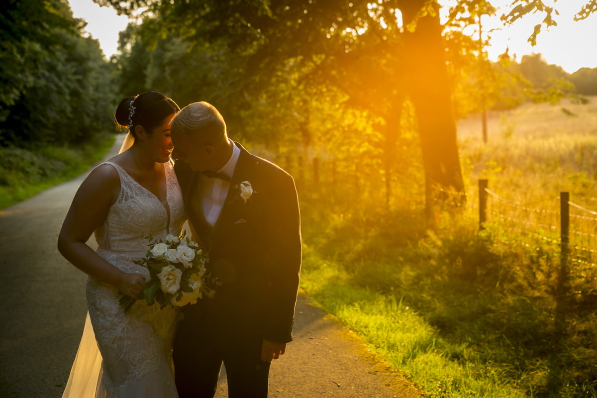 The bride and groom share an intimate moment in the summer sunlight