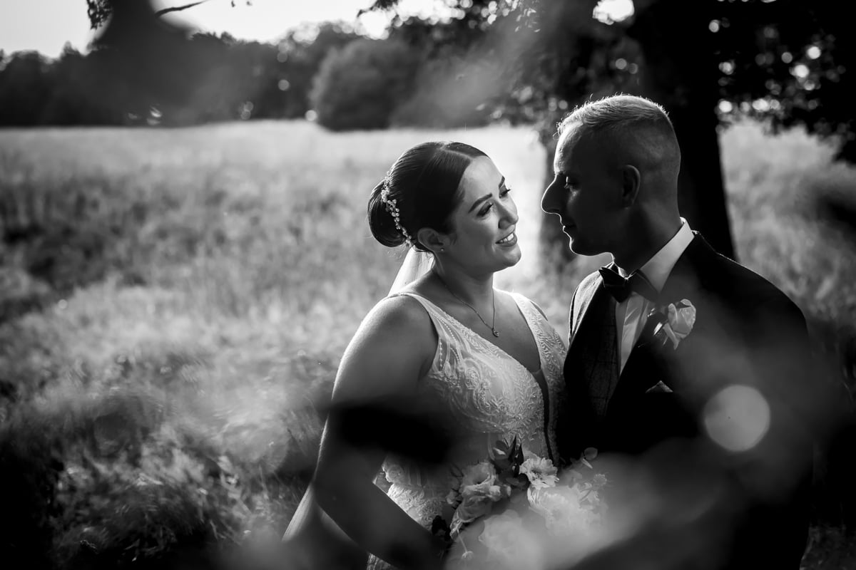 A natural portrait in black and white, of the bride and her groom in the countryside
