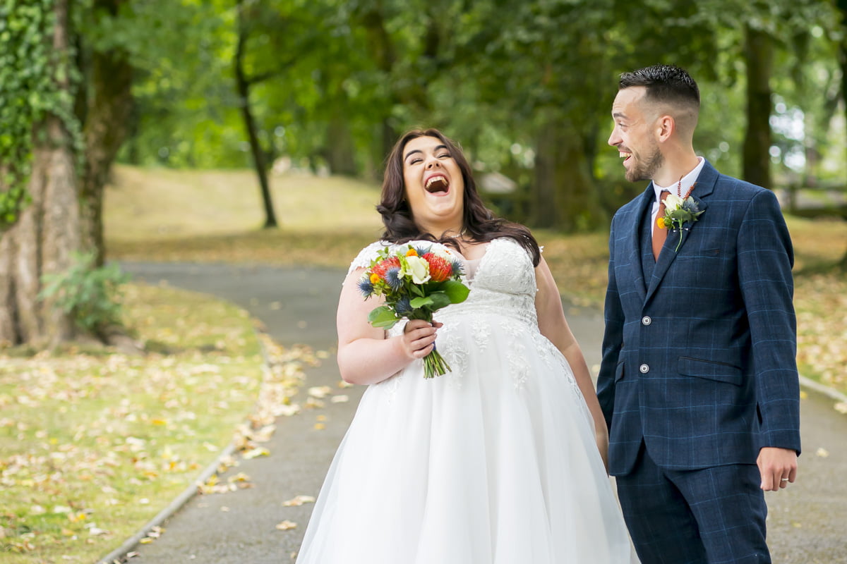 The bride throws her head back and laughs in a beautifully natural portrait