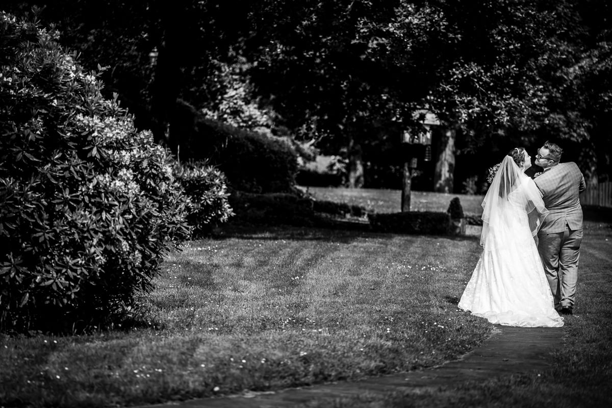 The bride and groom take a walk for some natural portraits, as the groom goes to kiss his bride