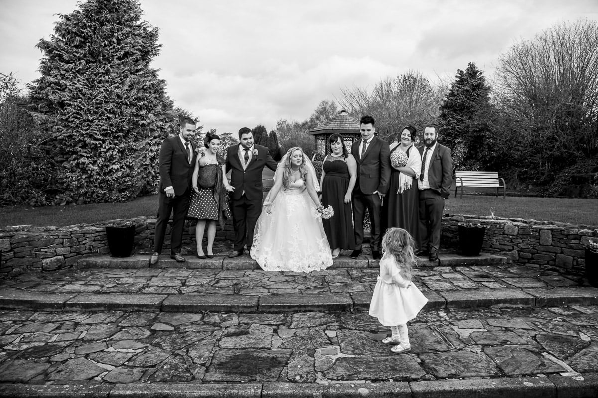 The wedding party poses for photos but the daughter has her own ideas group wedding photography