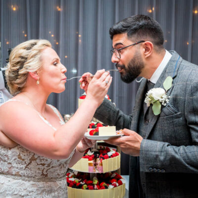 The bride and groom feed each other a bite of the wedding cake