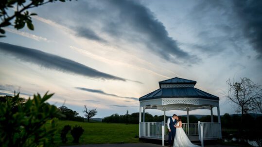 The bride and groom share a kiss in the pergola at Crow Wood